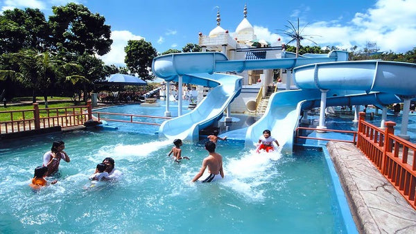 Swimmers in a wave pool at A'Famosa water park, with white domed towers behind.