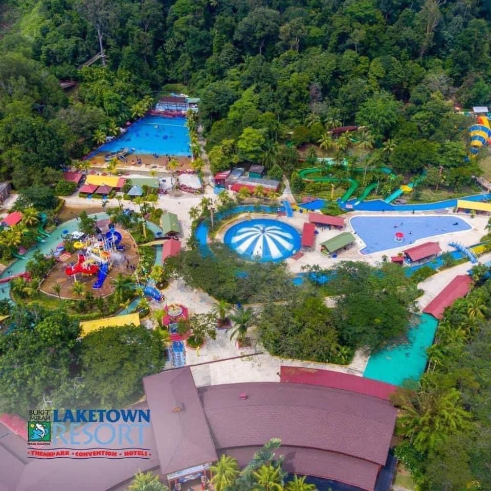 Aerial view of Bukit Merah Laketown Waterpark, its pools and slides set among forested hills.