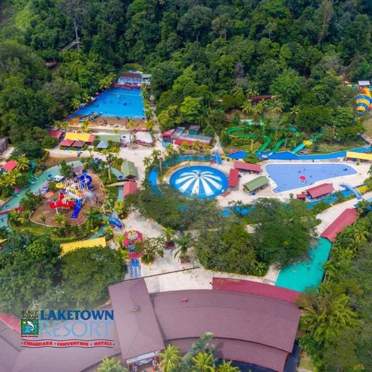 Aerial view of Bukit Merah Laketown Waterpark, its pools and slides set among forested hills.