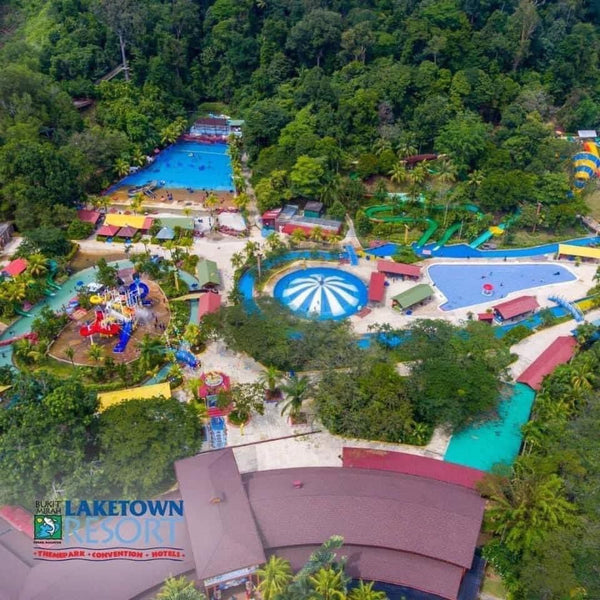 Aerial view of Bukit Merah Laketown Waterpark, its pools and slides set among forested hills.