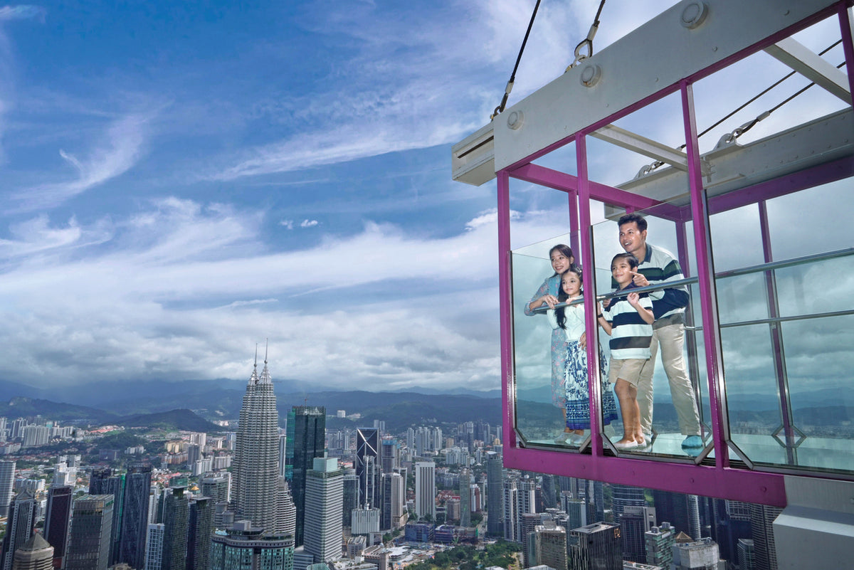 The glass Sky Box cube projecting out from the tower, a family standing inside it.