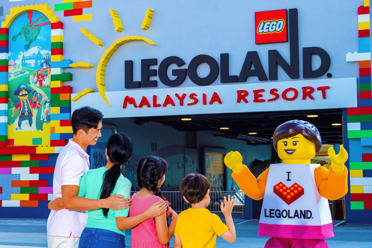 A family being greeted by a costumed LEGO minifigure character in an I love LEGOLAND shirt at the resort entrance.