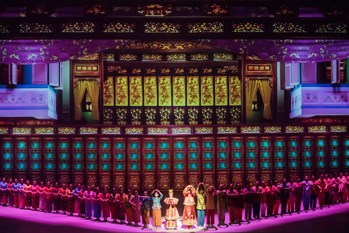 The full cast on stage in front of a gilded Peranakan house facade.