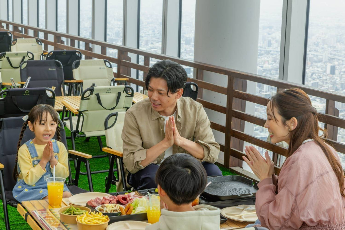 A family eating at a BBQ table beside the observatory windows