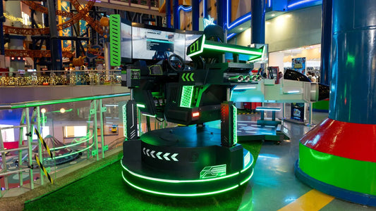 A green neon-lit simulator ride standing on an astroturf floor inside the mall.