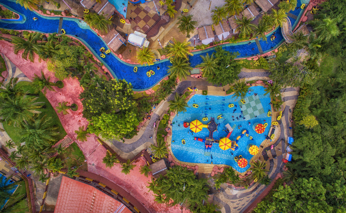 Aerial view of the A'Famosa water park, its blue lazy river winding between pools and pink pathways.