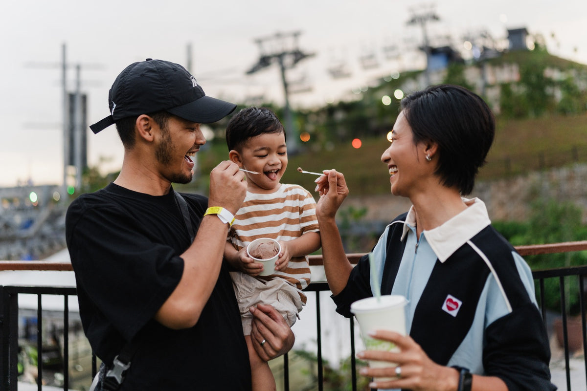 A family sharing ice cream on a terrace, the chairlift cables and hillside behind them.