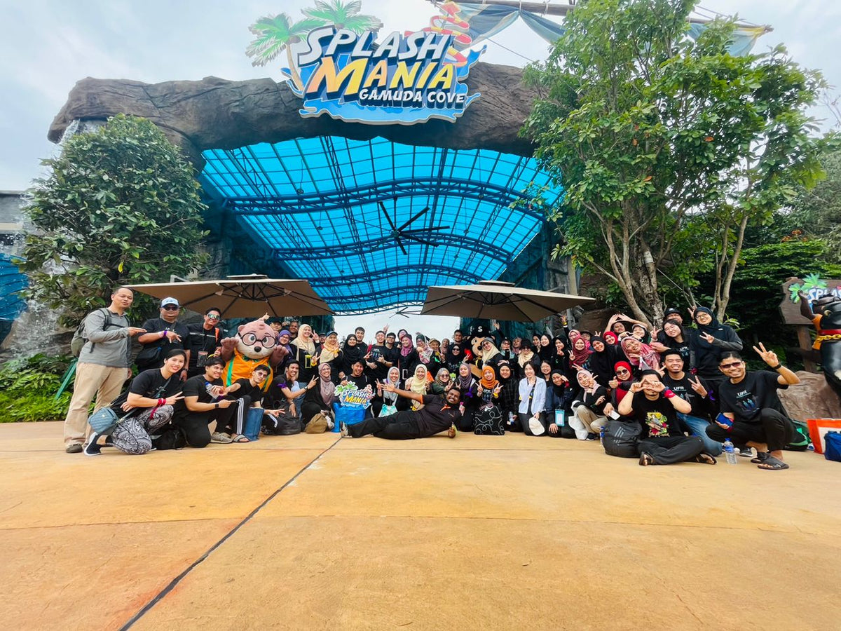A large group posed for a photograph under the park's entrance canopy.