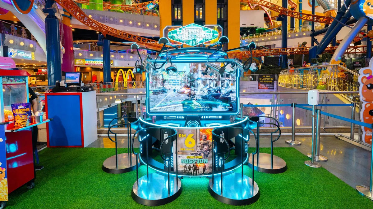 A circular arcade simulator with a large screen, on the indoor park floor.