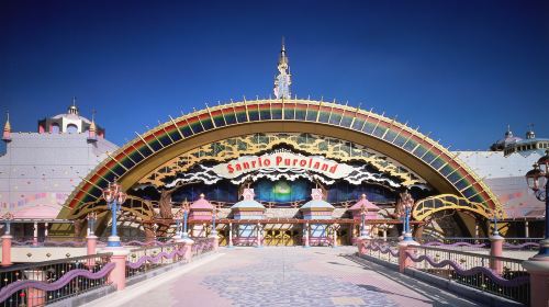 The illuminated entrance arch of Sanrio Puroland at dusk
