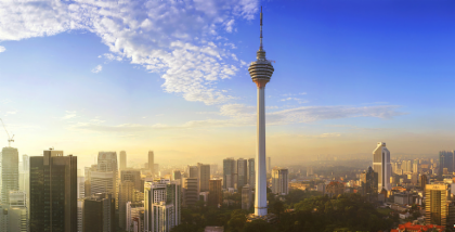 KL Tower rising above the Kuala Lumpur skyline at sunrise.