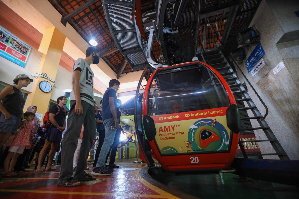Visitors queueing to board a red gondola inside the base station.