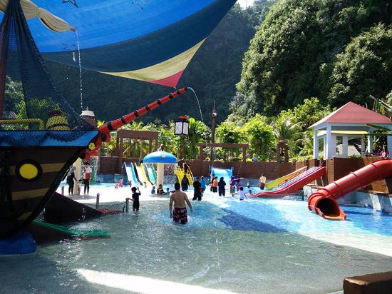A pirate ship play structure beside water slides in the water park.