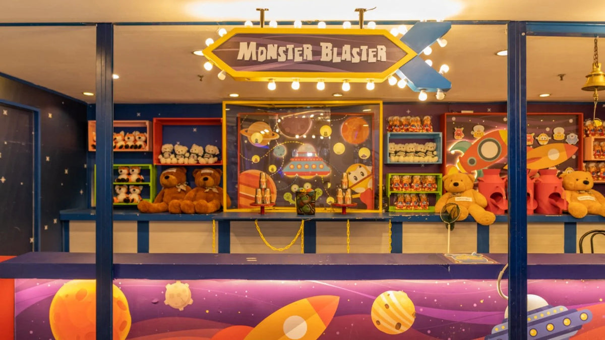 A Monster Blaster carnival game stall stocked with soft toy prizes.