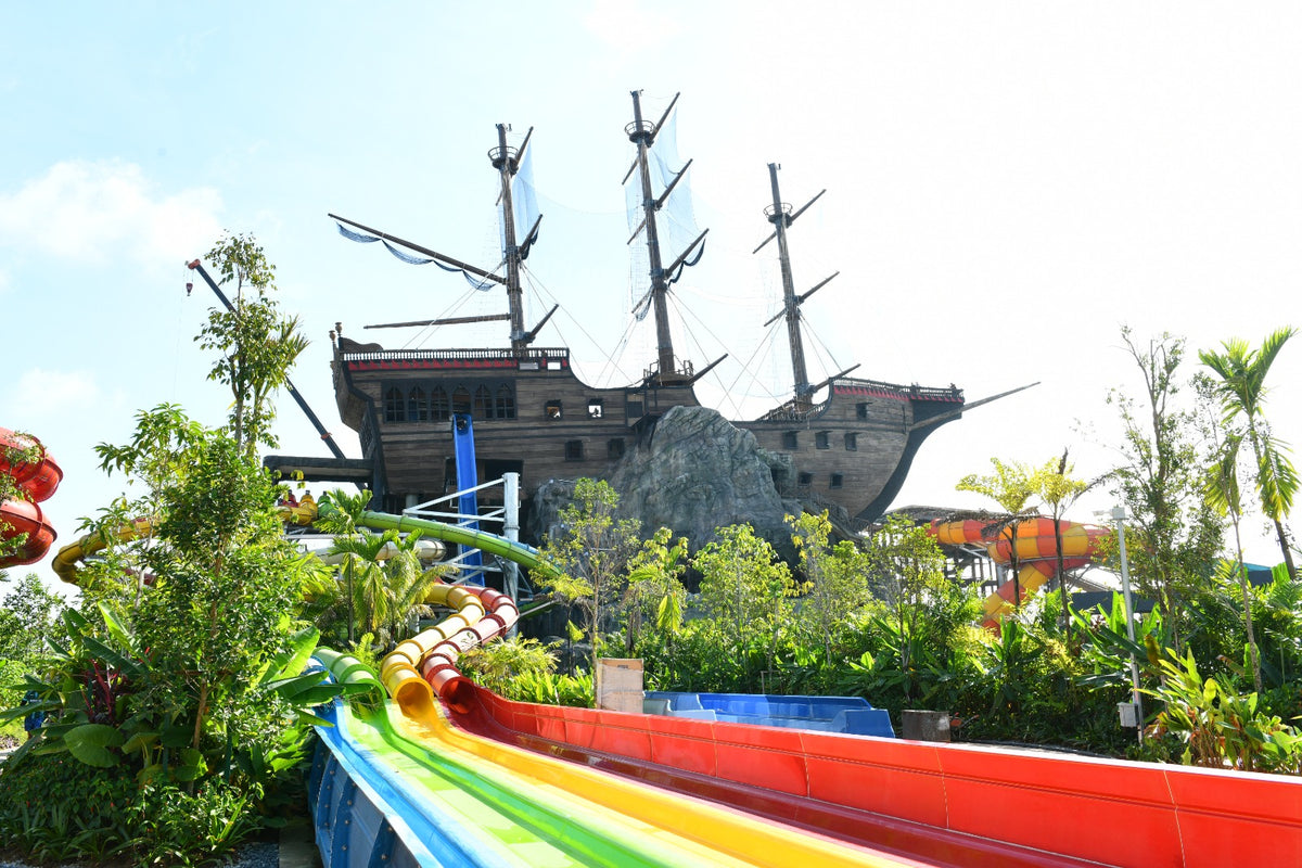 A pirate ship structure rising above rainbow-coloured racer slides.
