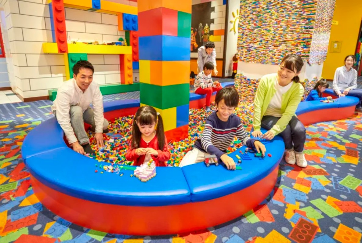Families building with LEGO bricks in an indoor play area at LEGOLAND Japan